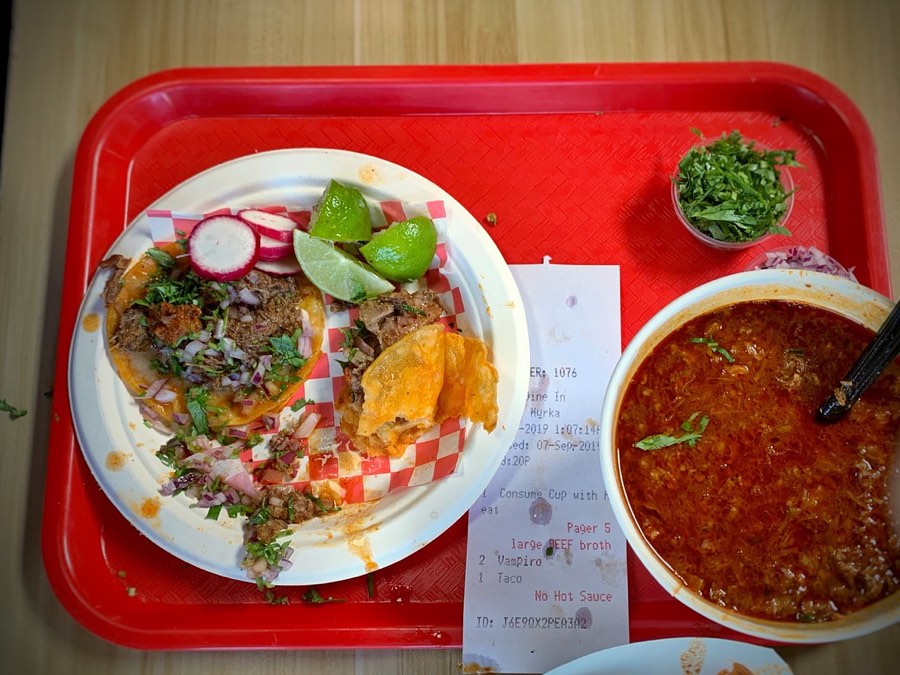 Birria tacos with a bowl of consomé